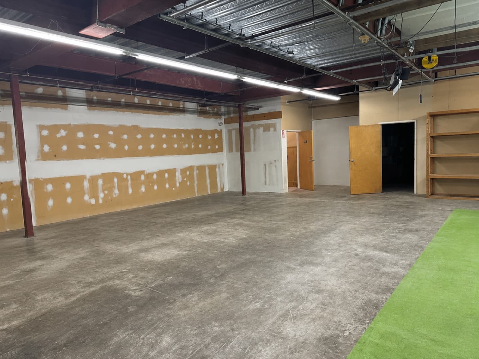 Wide view of warehouse showing back wall, structural columns, side doors